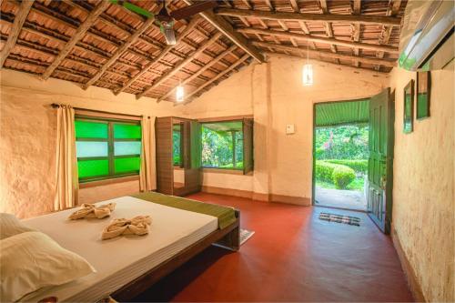 een slaapkamer met een bed met handdoeken erop bij Nature's Nest Eco Resort Goa, Near Dudhsagar Waterfalls in Molem