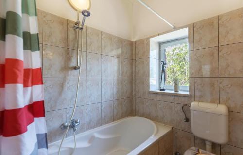 a bathroom with a tub and a toilet and a sink at Beautiful Home In Pula With Wifi in Pula
