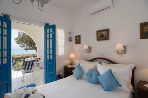a bedroom with a bed with blue doors and a patio at Lovely House Infront Of The Beach In Molos in Molos Parou
