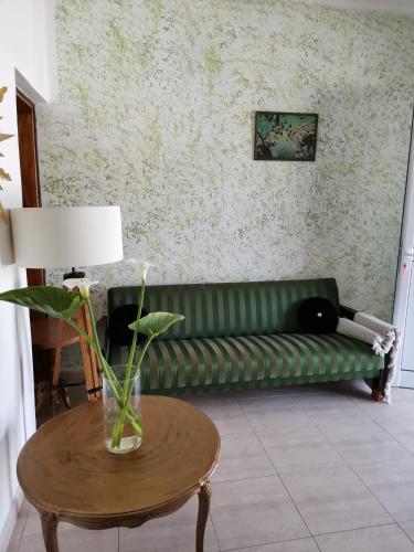 a living room with a green couch and a table at HAMBOULA in Polis Chrysochous