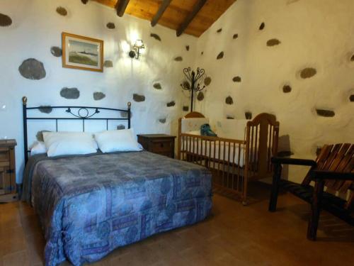 a bedroom with a bed and two babies in it at Finca Ancestros in Tejeda