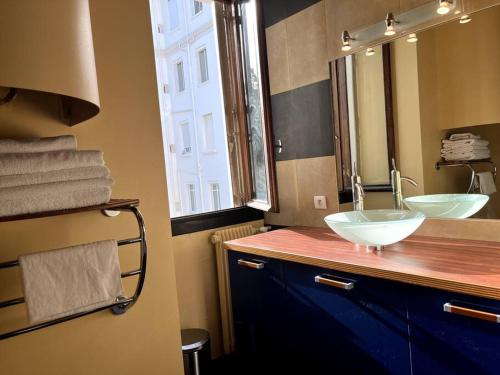 une salle de bain avec deux lavabos et un grand miroir dans l'établissement Cannes Montfleury grand confort, à Cannes