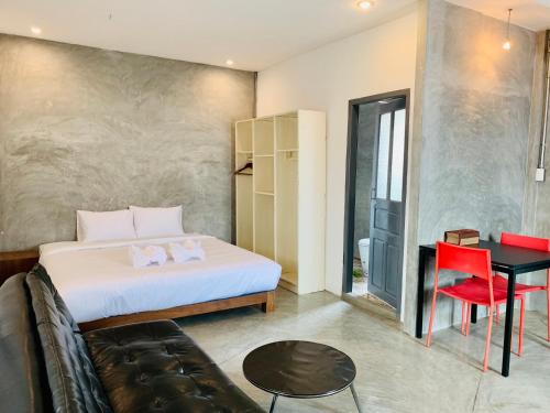 a bedroom with a bed and a table and a desk at La nuit de laos in Luang Prabang