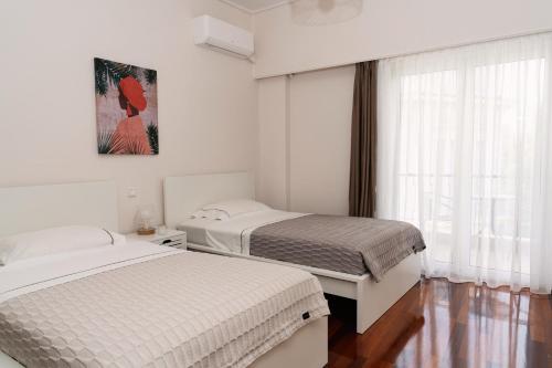 a bedroom with two beds and a window at Visum Acropol ,3BR - Private Terrace-Jacuzzi - Amazing View in Athens