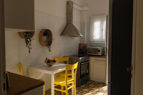 a kitchen with a white table and yellow chairs at Visum Acropol ,3BR - Private Terrace-Jacuzzi - Amazing View in Athens