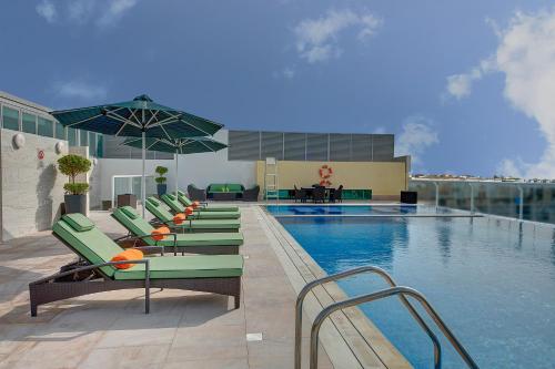 een zwembad met ligstoelen en een zwembad bij Al Khoory Atrium in Dubai