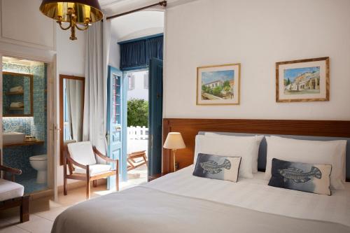 a bedroom with a large bed and a bathroom at Orloff Boutique Hotel in Hydra