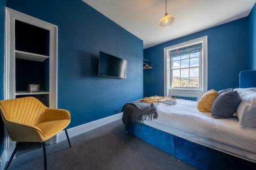 um quarto azul com uma cama e uma cadeira em Luxurious GRAND 6 BR Home in BATH - Perfect for Groups & Sleeps 12! em Bath