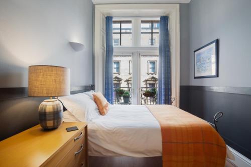 - une chambre avec un lit, un bureau et une fenêtre dans l'établissement West George Street Apartment, à Glasgow