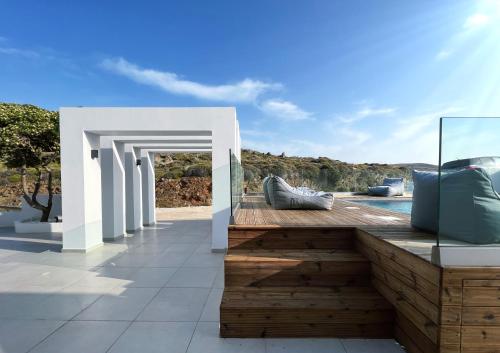 a wooden deck with a view of the ocean at The Thermia Suites in Kithnos
