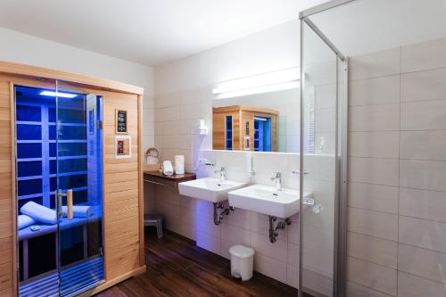 a bathroom with two sinks and a mirror at Burgls Apartmenthaus in Tröpolach