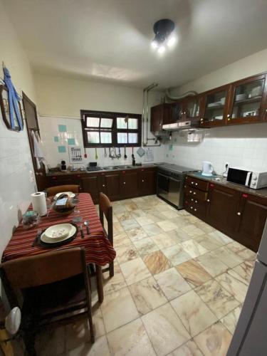 a kitchen with a table and chairs and a kitchen with at Suites Pinto Coelho in Caniço
