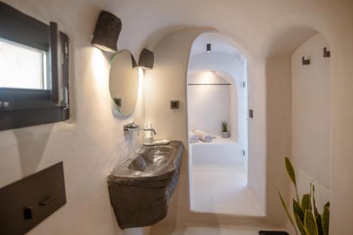 a bathroom with a sink and a mirror at One of One - Aether in Oia