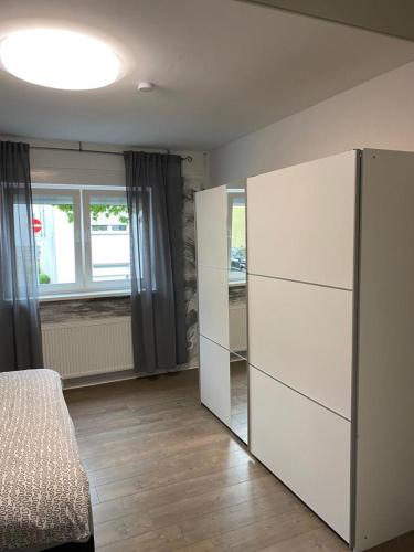 1 dormitorio con cama y espejo en la pared en Ferienwohnung Da Emi, en Neunkirchen