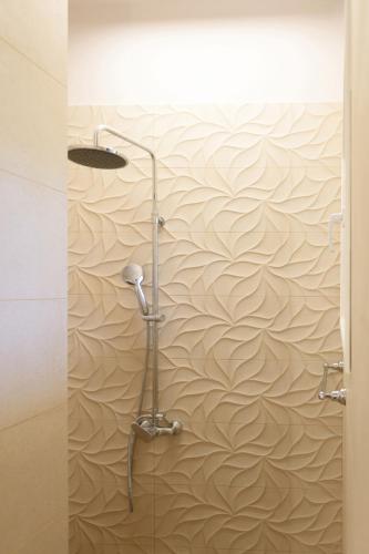 a shower stall in a bathroom with a wave wallpaper at Villa Armeni by CorfuEscapes in Corfu