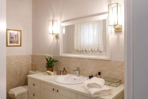 y baño con lavabo, espejo y aseo. en Villa Armeni by CorfuEscapes, en Corfú