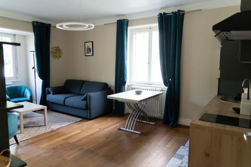 a living room with a blue couch and a table at Yapot in Colmar