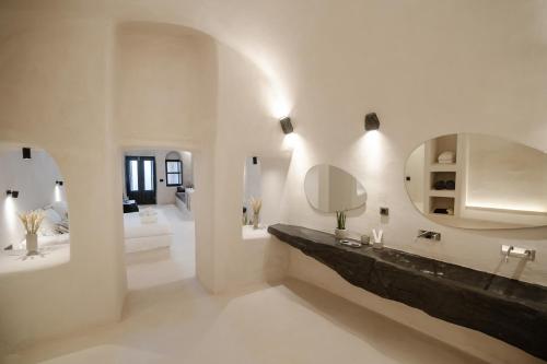 a bathroom with a sink and a mirror at One of One - Aurelia in Oia
