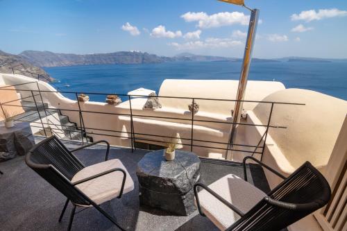 a balcony with chairs and a table on a boat at One of One - Aurelia in Oia