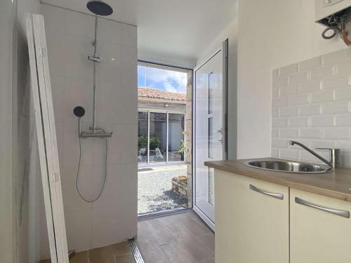 - une cuisine avec une douche, un évier et une porte dans l'établissement Maison rénovée 4 pièces, 6 couchages, terrasse, proche commerces et plages - Saint-Pierre-d'Oléron - FR-1-246A-215, à Saint-Pierre-dʼOléron