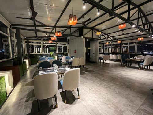 a dining room with tables and chairs and lights at Royal Ace Boutique Hotel - Manyata Techpark in Bangalore