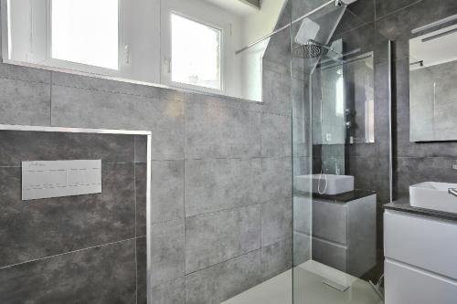La salle de bains est pourvue d'une douche en verre et d'un lavabo. dans l'établissement Cocon pour 4 proche du Golf Bluegreen, à Pléneuf-Val-André