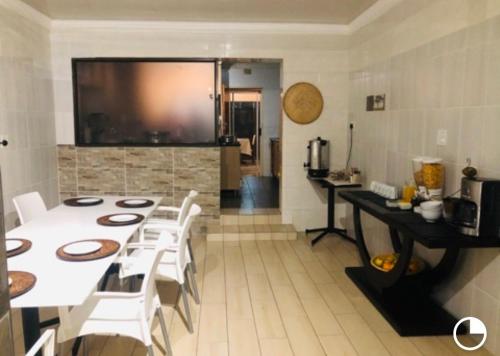 a dining room with a white table and white chairs at Ankuweni Guest house in Giyani