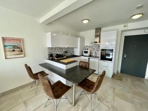 une cuisine avec une table et des chaises dans une pièce dans l'établissement Quiberon - Appartement cosy 40m² - 4 pers - Proche plage - Balcon SW - Parking privé - Animaux OK - FR-1-478-248, à Quiberon