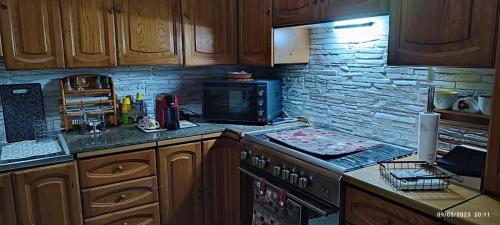 a kitchen with wooden cabinets and a stove top oven at ToMa House in Pellaro
