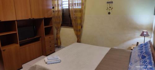 a bedroom with a bed and a television in a room at ToMa House in Pellaro