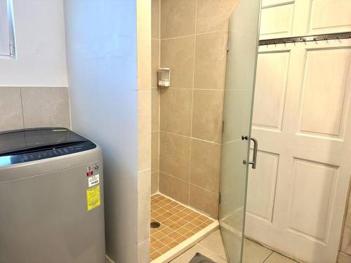 a shower with a glass door in a bathroom at Maho Beach House - Charming Studio - Beach Access in Maho Reef