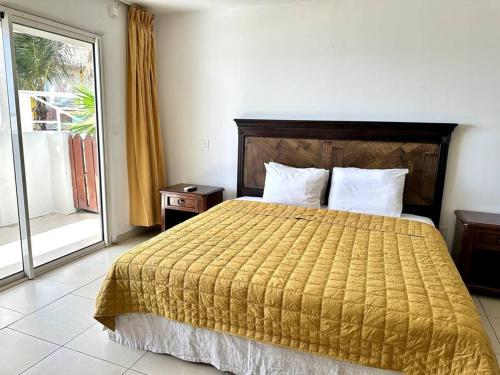 una camera d'albergo con un letto e una porta scorrevole in vetro di Charming Maho Beach Bar Studio a Maho Reef