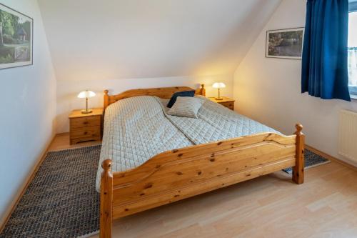 ドルヌムにあるFerienwohnung Mareikeのベッドルーム1室(木製ベッド1台、ナイトスタンド2台付)