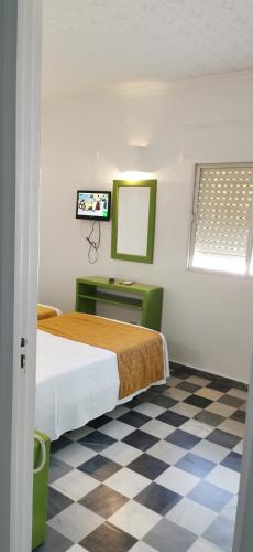 a bedroom with a bed and a checkered floor at Hotel El Puntazo I in Mojácar
