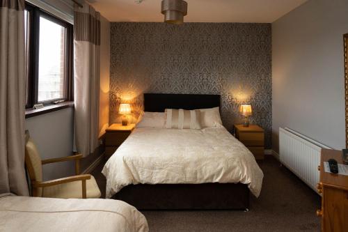 紐卡索的住宿－Golf Links House，一间卧室配有一张床,两盏台灯放在两张桌子上