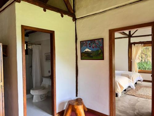 1 dormitorio con cama y baño con espejo. en Casa iLayaku, en Guangopolo