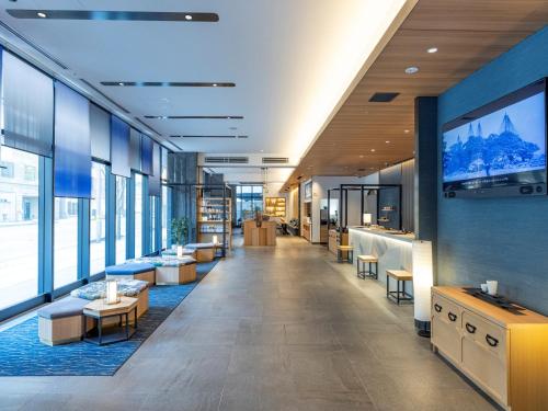 un atrio di un edificio con tavoli e sedie di Tokyu Stay Kanazawa a Kanazawa