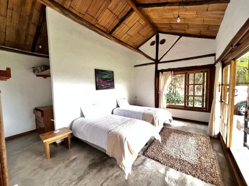 sypialnia z 2 łóżkami i dużym oknem w obiekcie Casa iLayaku w mieście Guangopolo