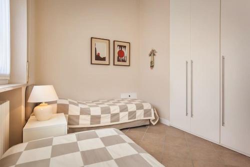 a bedroom with two beds and a table with a lamp at Villetta Olivi - Vista mozzafiato in Torri del Benaco