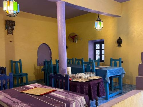 a dining room with blue tables and blue chairs at Merzouga Camp and Hostel in Merzouga