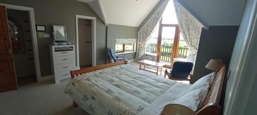 um quarto com uma cama e uma grande janela em Ocean view em Castlemartyr