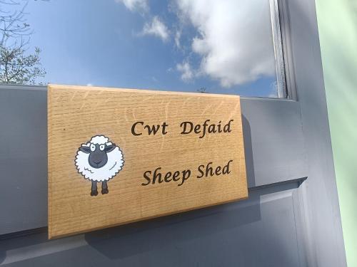 a sign with a sheep on the side of a building at MotoCamp Wales -Camping Pods in Dolgellau
