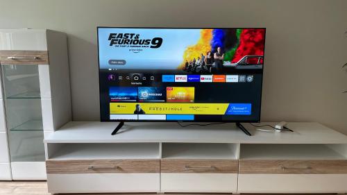 a flat screen tv sitting on top of a white cabinet at Apart70-Modern Design I Garden with Terrace I Smart TV I Free Parking I Free WiFi in Hamm