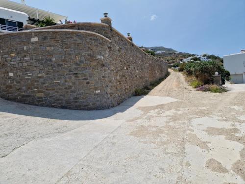 a brick wall next to a dirt road at Panos Luxury Suite in Parikia