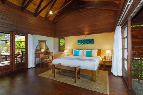 a bedroom with a bed in a room with wooden walls at JA Enchanted Island Resort Seychelles in Round Island