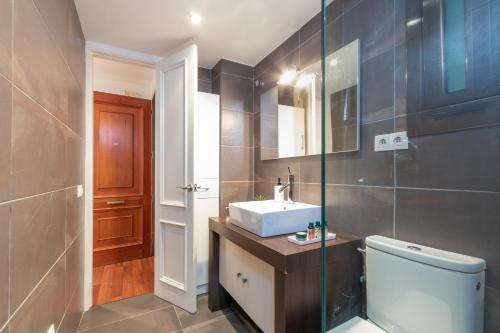 W łazience znajduje się umywalka, toaleta i lustro. w obiekcie Maria Beach w mieście Platja  d'Aro