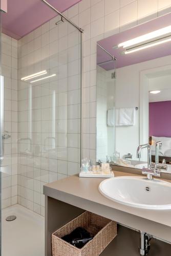 a bathroom with a sink and a shower at Boutique Hotel KARL in Luzern