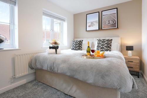 a bedroom with a large bed with a tray of fruit on it at Stylish House - Close to City Centre and Luton Airport - Free Parking, Super-Fast Wifi, Garden and Smart TV with Netflix by Yoko Property in Luton
