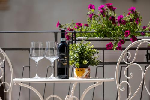 a table with two glasses and a bottle of wine at Domus Federiciana in Castellammare del Golfo
