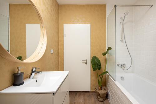 een badkamer met een wastafel, een douche en een spiegel bij Casa269b - Cozy house with scandinavian design in Moieciu de Jos
